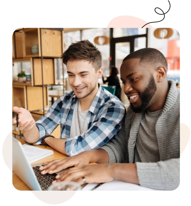 Two men collaborating on a laptop, discussing work together.